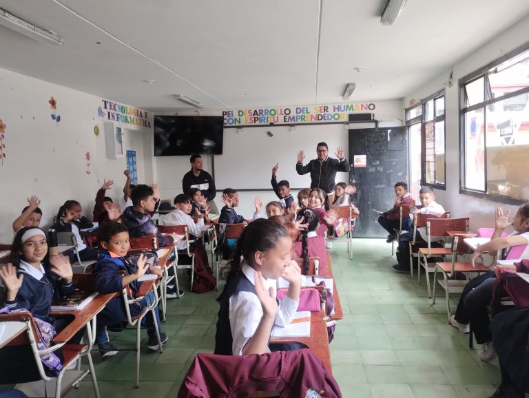 Un grupo de estudiantes compone palabras con letras recortadas sobre la mesa