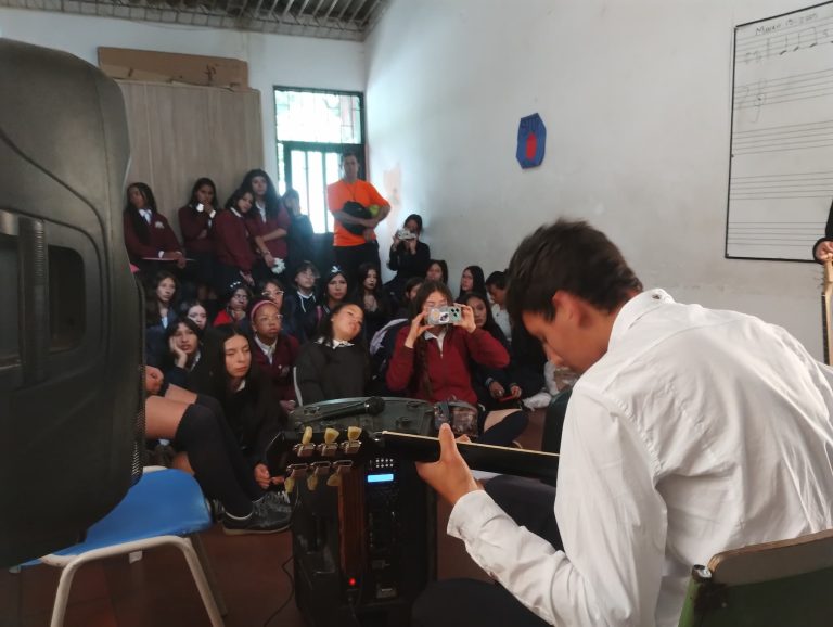 Estudiantes reunidos en el salón durante un ensayo del semillero musical