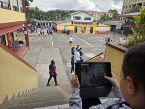 Vista del patio y las escaleras del colegio con estudiantes en el descanso