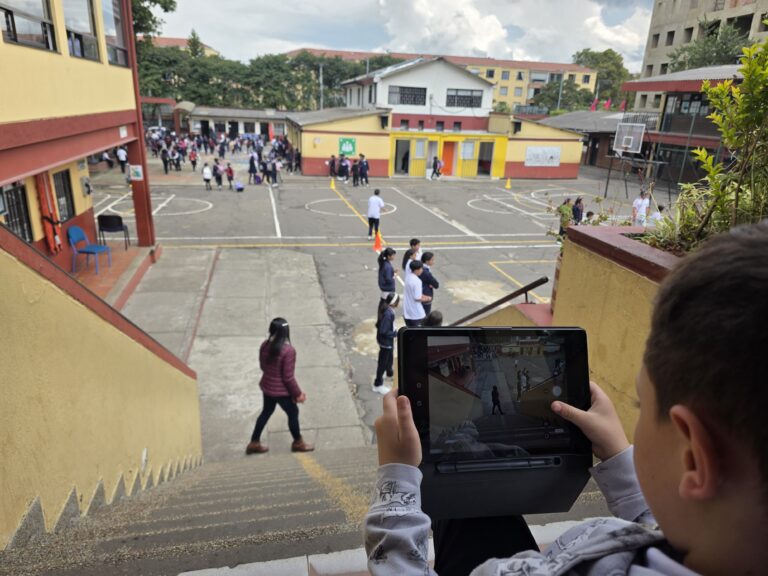 Vista del patio y las escaleras del colegio con estudiantes en el descanso