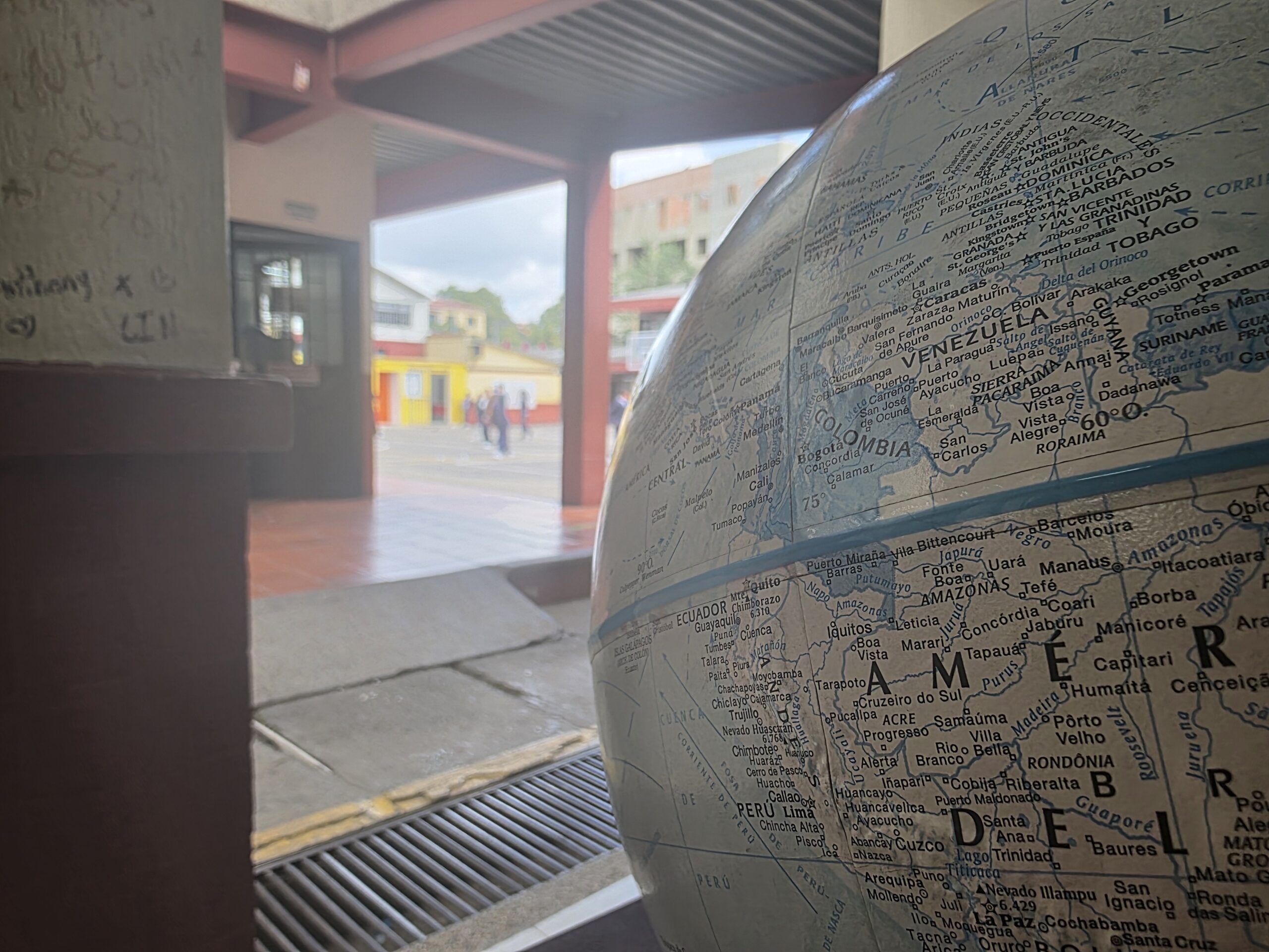 Globo terráqueo en el pasillo lector del colegio, con el patio al fondo