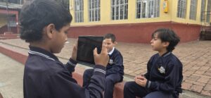 Detalle de la tablet encuadrando a los estudiantes entrevistados en el patio del colegio