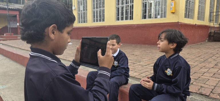 Detalle de la tablet encuadrando a los estudiantes entrevistados en el patio del colegio