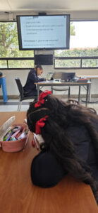 Detalle de la diapositiva con la definición de entrevista y una estudiante escribiendo su guion