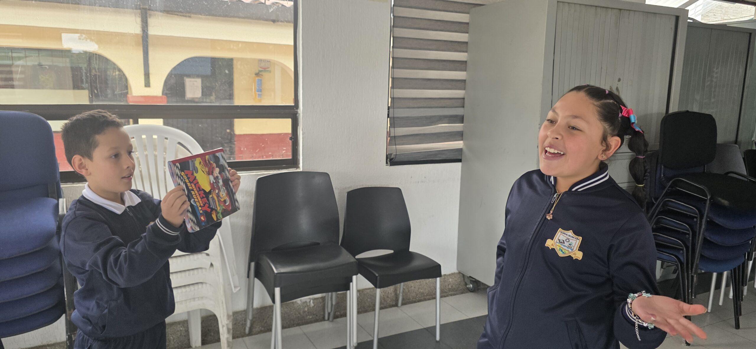 Un estudiante sostiene con las dos manos la tablet del proyecto mientras graba a una compañera